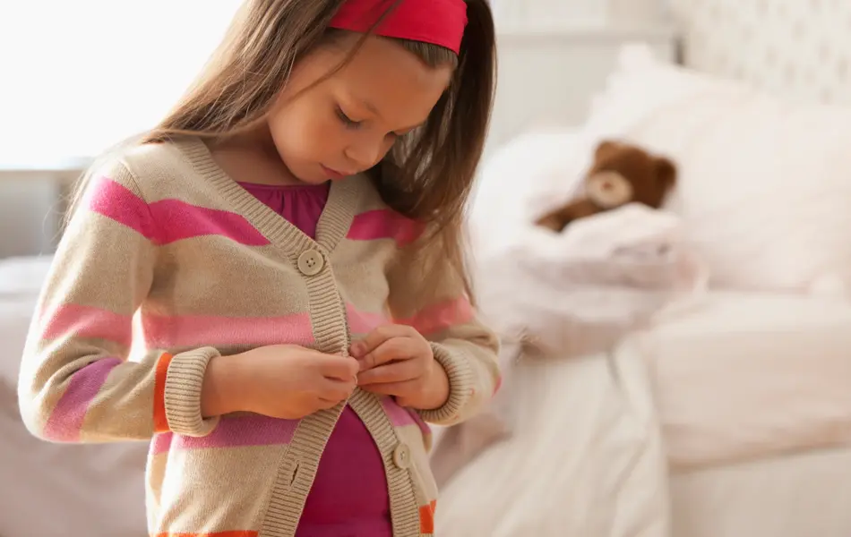 jente som kler på seg selv til skolestart