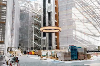 Bilde fra renoveringen av atriet i Vika Atrium med byggematerialer og utstyr på gulvet og vegger kledd i stillas og presenning