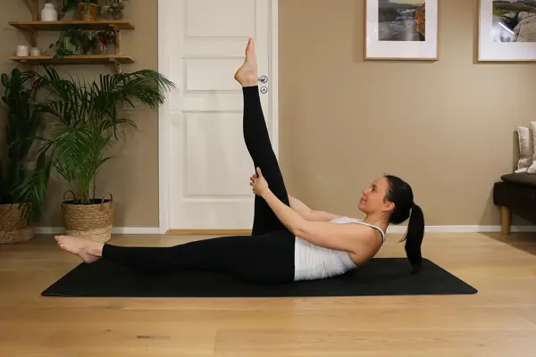 Anna viser Pilates-øvelser på treningsmatte på gulvet