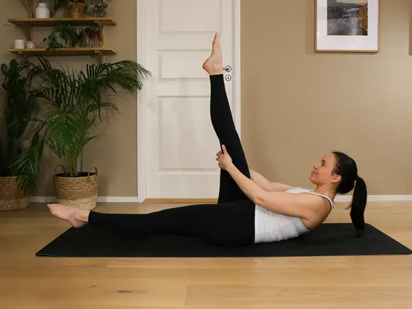 Anna viser Pilates-øvelser på treningsmatte på gulvet