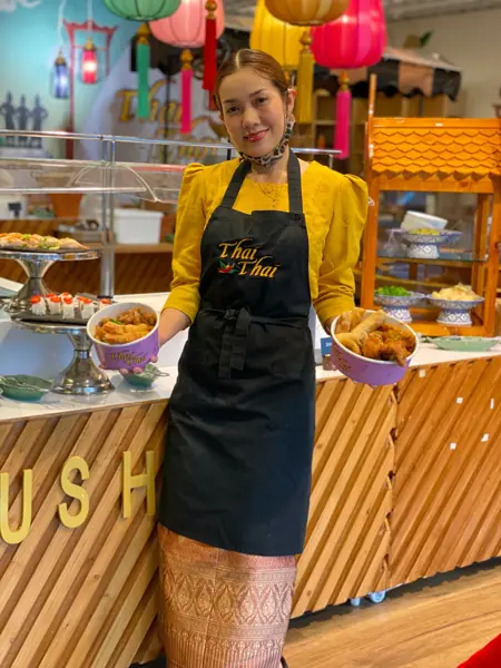 Dame holder to take-away skåler med thai mat