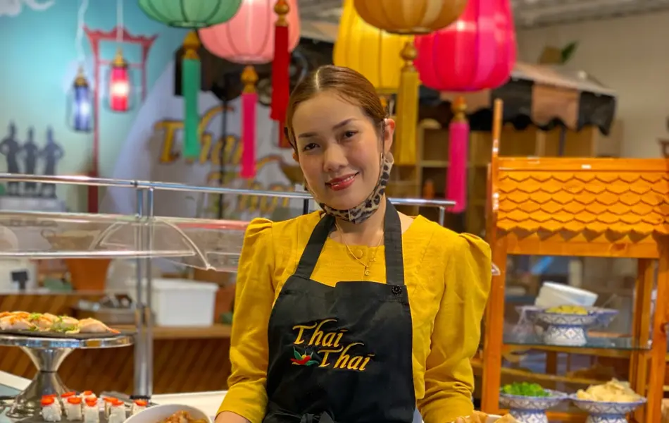 Dame holder to take-away skåler med thai mat