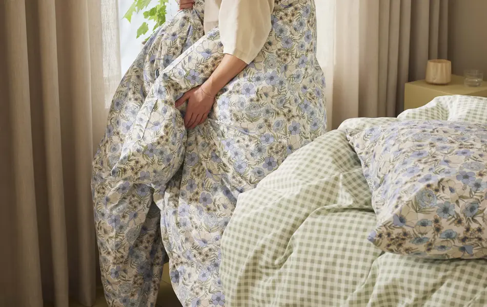 Dame med dyne i blomstermønster rundt seg