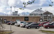 Thon Senter Pyramiden fasade, med parkeringsplass og logo på vegg.
