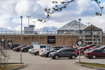 Thon Senter Pyramiden fasade, med parkeringsplass og logo på vegg.
