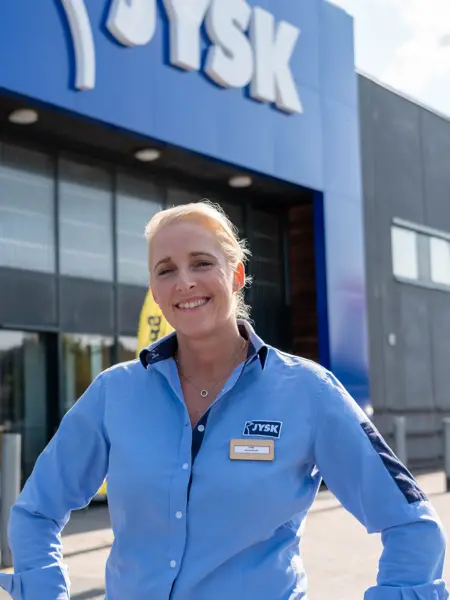 en ansatt utenfor inngangen til jysk