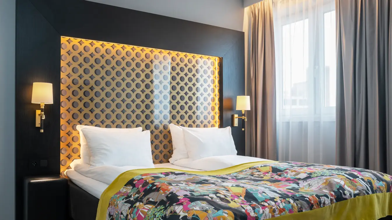 Dobbeltseng, vindu, beige gardiner, parkettgulv