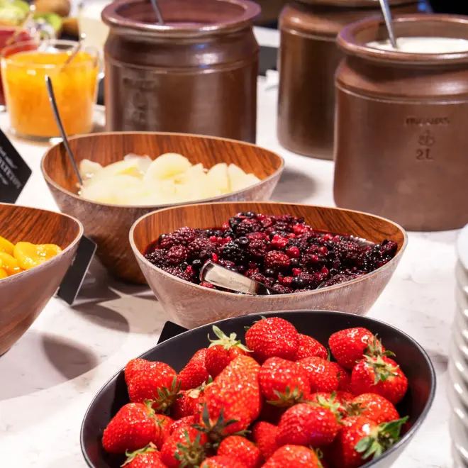 Friske bær på frokostbuffet Glassflasker med smoothie og små begre med yoghurt på Thon Hotel Arena i Lillestrøm