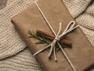 Pakke i gråpapir og dekorert med kanelstang