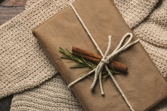 Pakke i gråpapir og dekorert med kanelstang