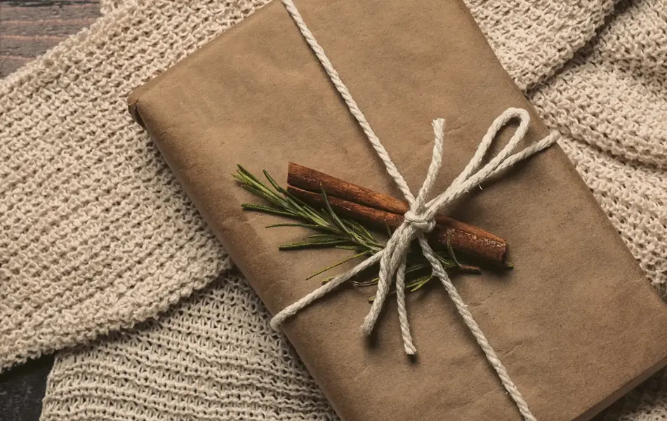 Pakke i gråpapir og dekorert med kanelstang