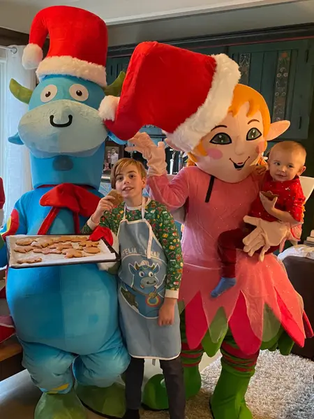 Amfelia og Oskar sammen med to barn, holder opp et brett med pepperkaker