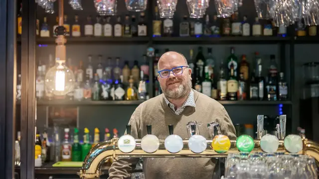 Bilde av mann bak bardisk