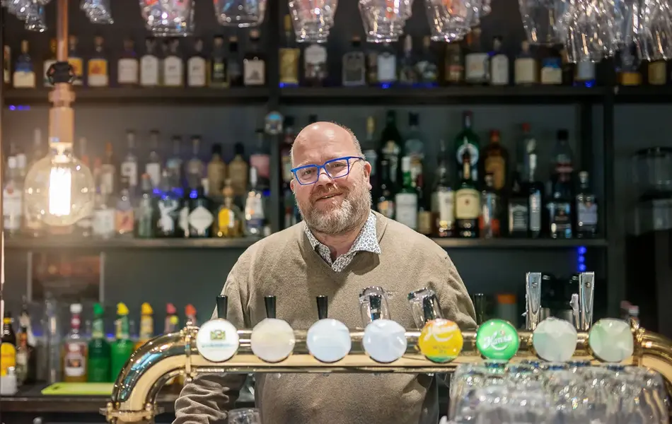 Bilde av mann bak bardisk