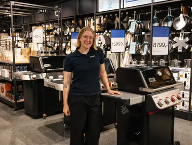 dame står ved grill i butikk