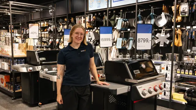 dame står ved grill i butikk