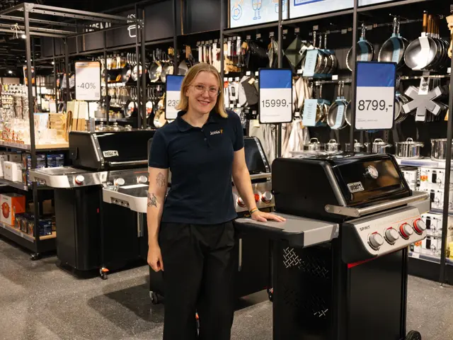 dame står ved grill i butikk