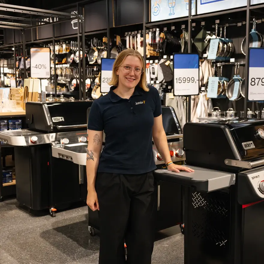 dame står ved grill i butikk