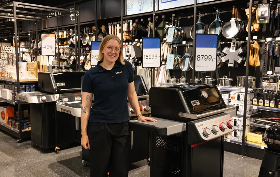 dame står ved grill i butikk