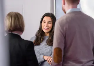 En mann og to kvinner som står i et rom