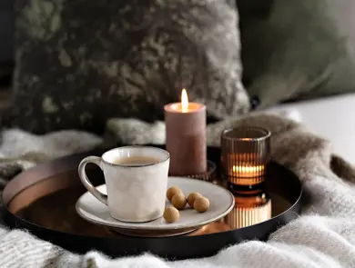 Brett med kaffekopp, snacks og kubbelys