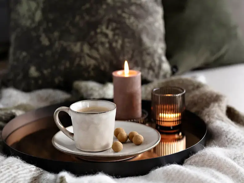 Brett med kaffekopp, snacks og kubbelys