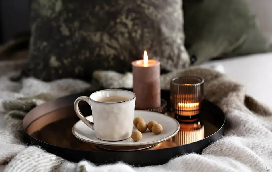 Brett med kaffekopp, snacks og kubbelys