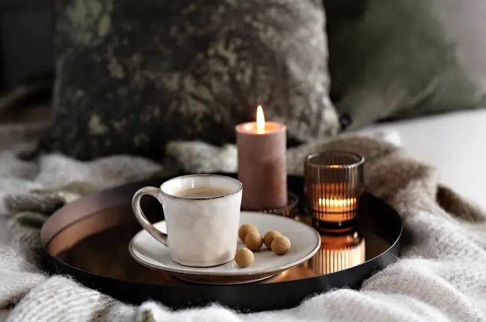 Brett med kaffekopp, snacks og kubbelys