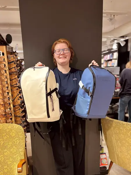 Ansatt som holder opp to ryggsekker