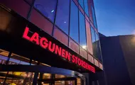 Nærbilde av fasaden til Lagunen Storsenter med skilt hvor senterets navn fremkommer med store; røde bokstaver.