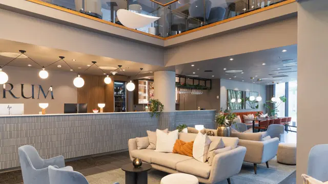 Lobbyområde med resepsjonsdisk, sofa, og lenestoler 