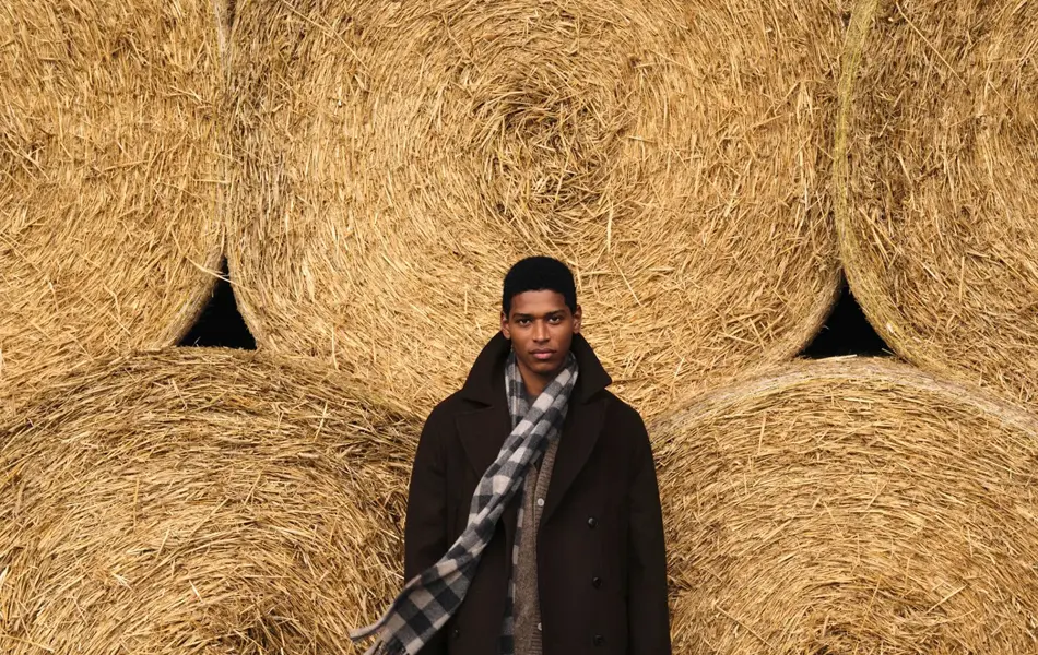 Mann som står foran store høyballer