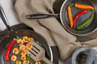 To stekepanner med scampi og chilipepper.