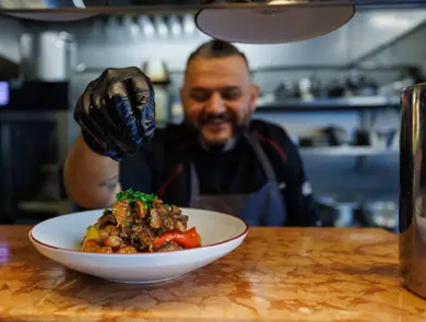 Man smiler foran en tallerken med mat
