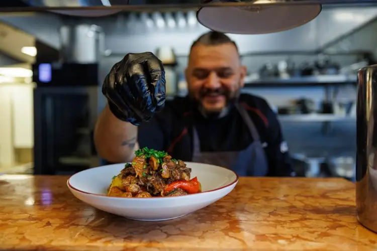 Man smiler foran en tallerken med mat