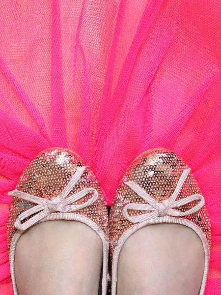 Glitrende ballerinasko med sløyfe mot et rosa tyllstoff