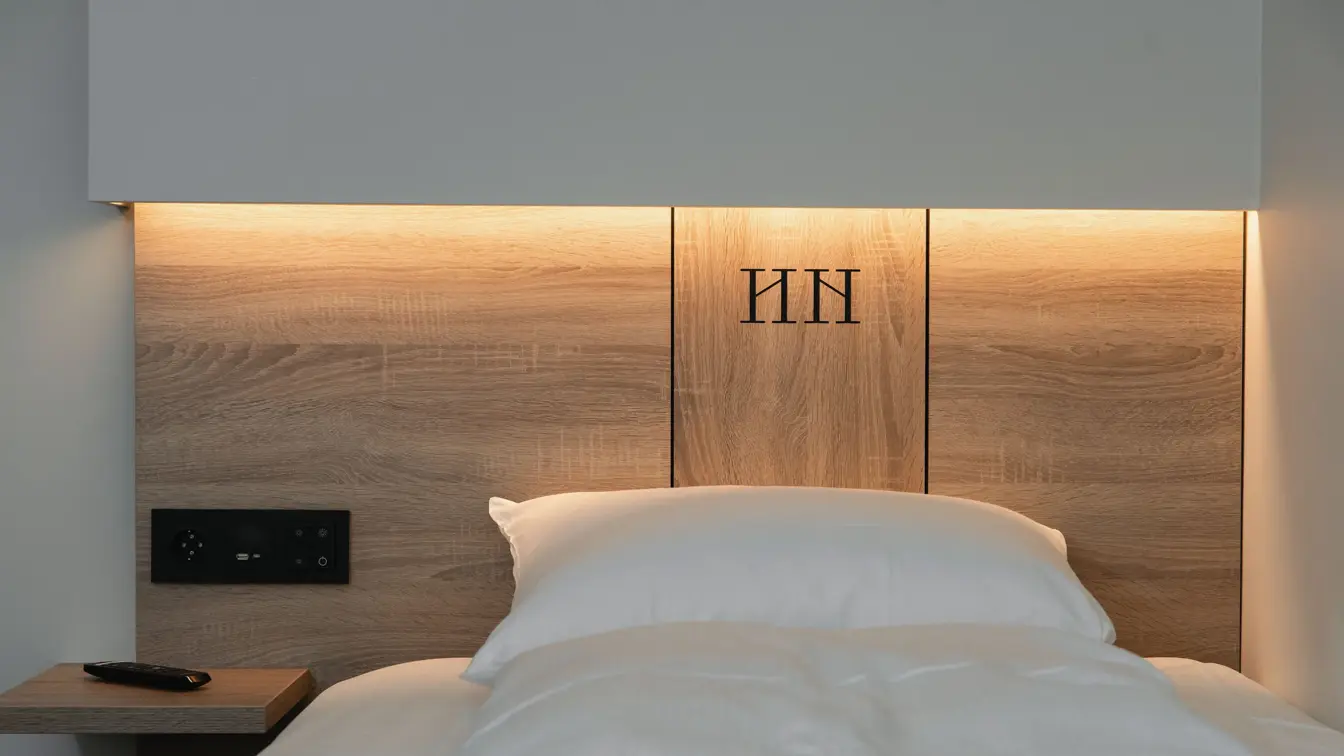 Sengegavl i træ og hvit vegger. I superior room på Thon Hotel Norge i Kristiansand.