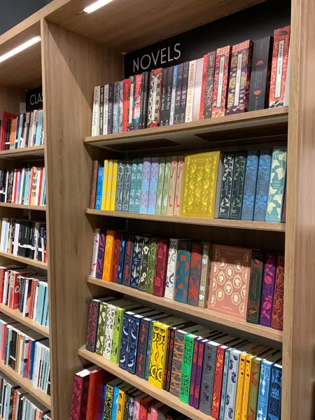 Norli med eikebokhyller fra gulv til tak fylt med bøker i ulike sjangre