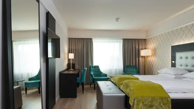 Dobbeltseng med to lenestoler og arbeidspult i superior room på Thon Hotel Oslofjord i Sandvika