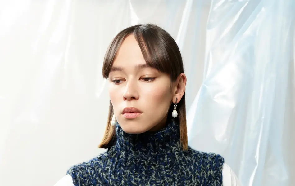 Kvinnelig modell som poserer i strikket hals fra Rauma