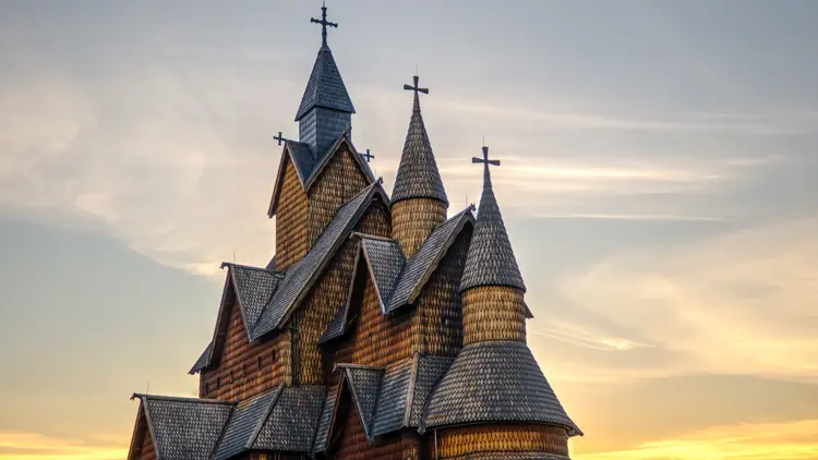 The colossal Heddal stave church looked more astounding as the sun sets on a fine afternoon in Notodden, Norway. The Heddal stave church is the largest and most beautiful stave church in Norway. This triple nave stave church was built in the 1200's and has been restored multiple times.