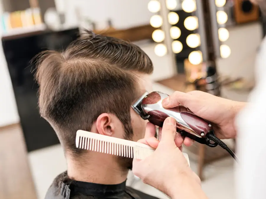 frisør som barberer håret til en mann