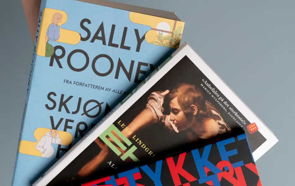 Hånd som holder tre bøkera