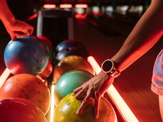 Bowlingkuler på rekke i grønn, oransje, blå og rosa