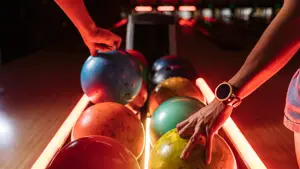 Bowlingkuler på rekke i grønn, oransje, blå og rosa