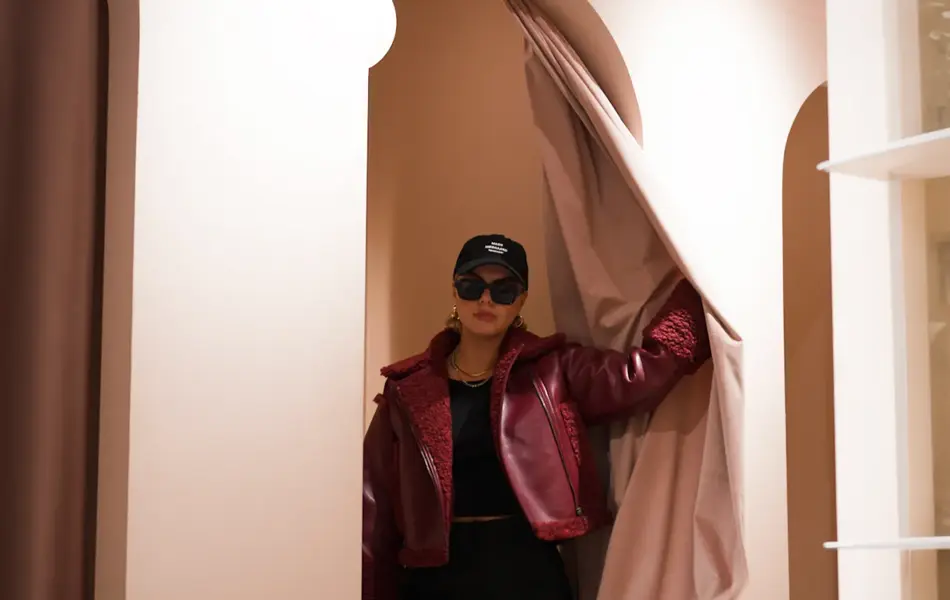 Damed med jakke, caps og solbriller