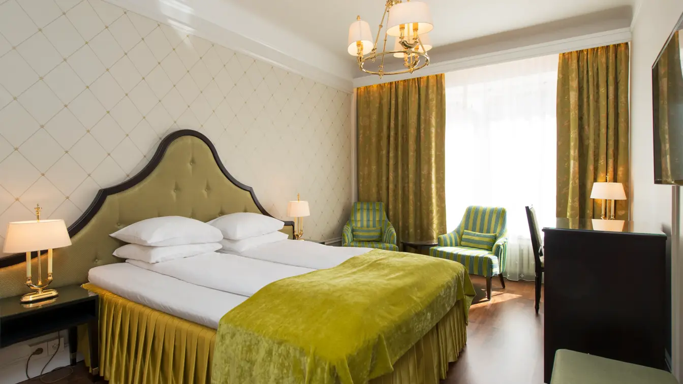 Dobbeltseng to godstoler og skrivepult på Hotel Bristol i Oslo sentrum