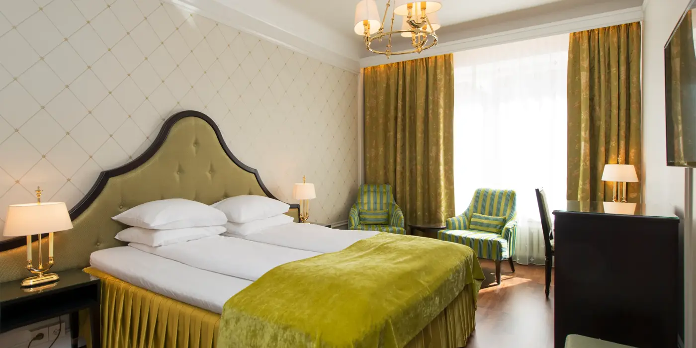 Dobbeltseng to godstoler og skrivepult på Hotel Bristol i Oslo sentrum