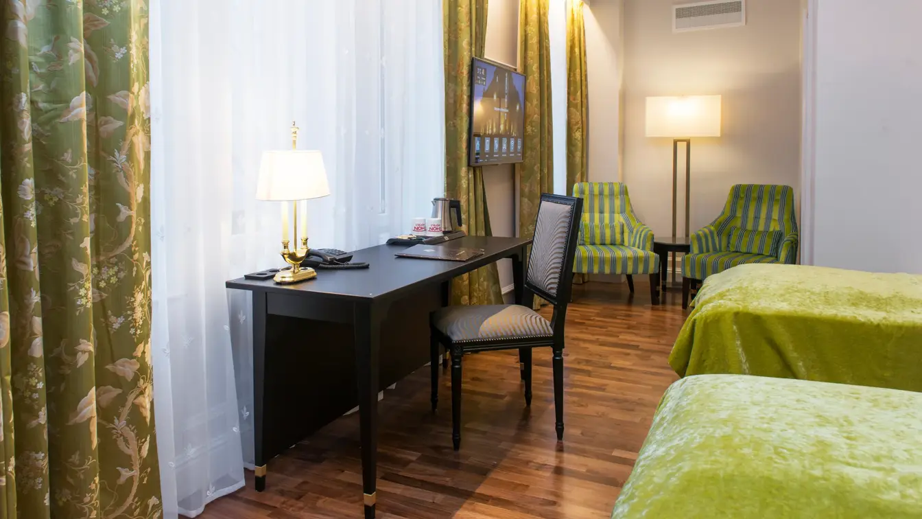 To enkeltsenger, skrivepult og to lenestoler på Hotel Bristol i Oslo sentrum