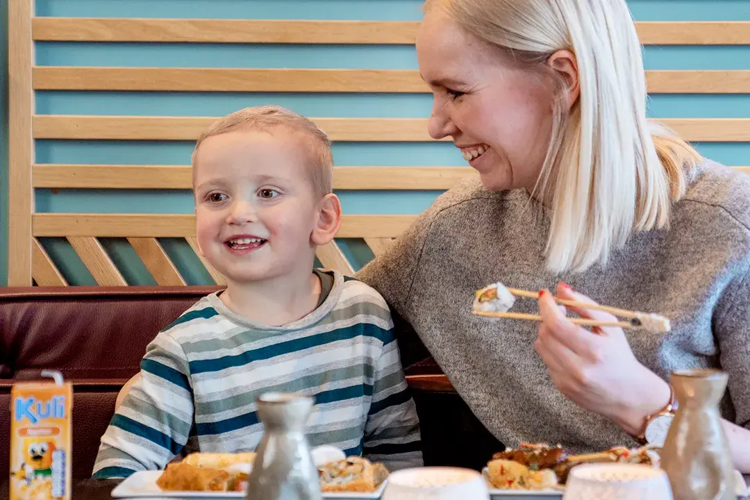 mor og sønn spiser på restaurant med godt humør